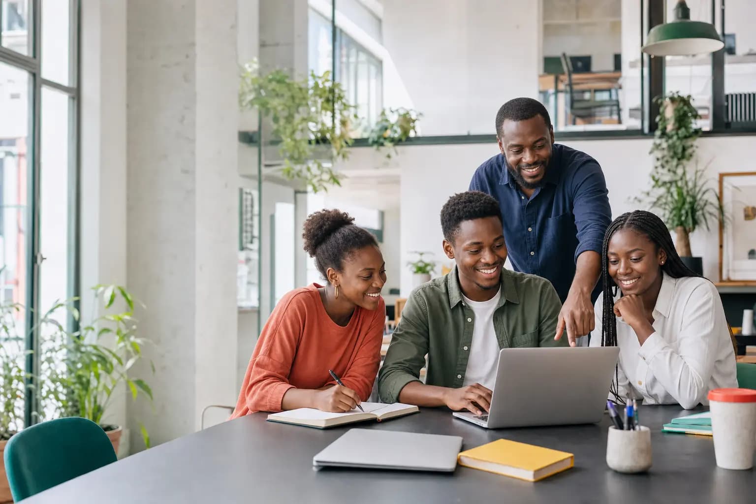 Des apprenants travaillent avec un mentor autour d'un ordinateur